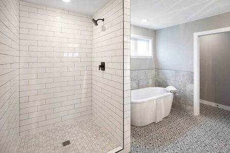 Tiled bathroom with standalone tub in master bathroom