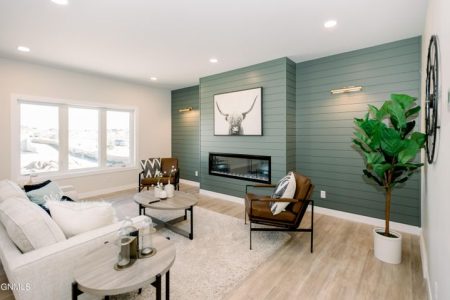 Interior of an open-concept living area with customized green colored wood accent wall and fireplace